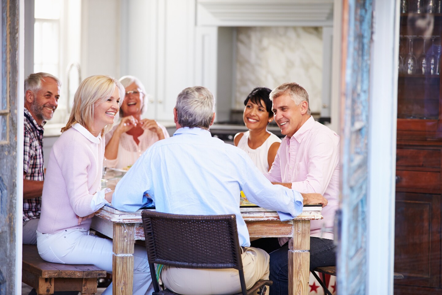 Eine Gruppe von Menschen sitzt um einen Tisch und unterhält sich in einer gemütlichen Umgebung.